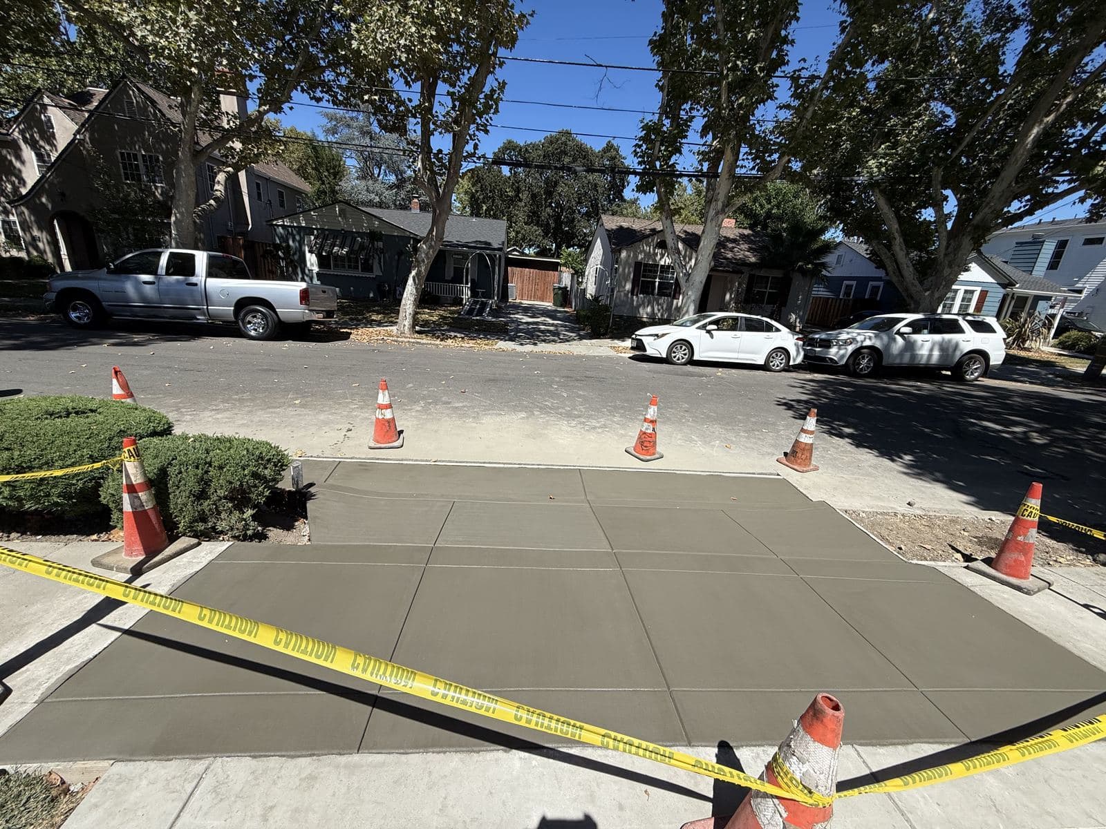 New concrete driveway apron curing in front of a Bay Area home